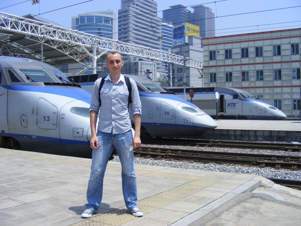 Denys on the platform next to KTX (Korea Train Express) high-speed trains at Seoul Station in South Korea.